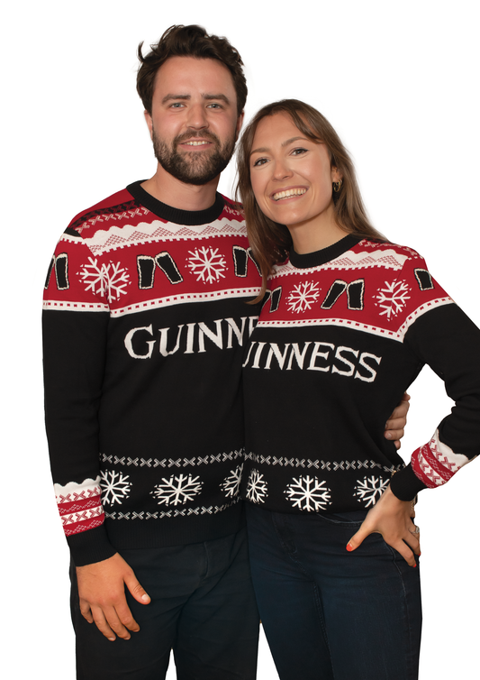 Two people donning festive Official Guinness Christmas Jumpers.