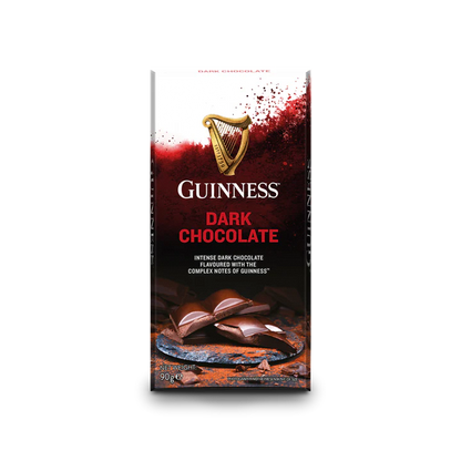 The packaging of the Guinness Luxury Dark Chocolate Bar showcases a peeling chocolate bar alongside the iconic Guinness logo, accompanied by the description "Intense dark chocolate flavored with the complex notes of Guinness." This luxurious treat is elegantly offered in a 90g bar, ideal for those desiring indulgence.