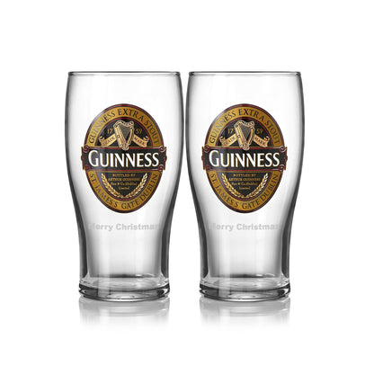 The Guinness UK Classic Collection Pint Glass 2 Pack, featuring vintage logos, displays two elegant empty glasses side by side on a reflective surface, ideal for any beer glass collection.