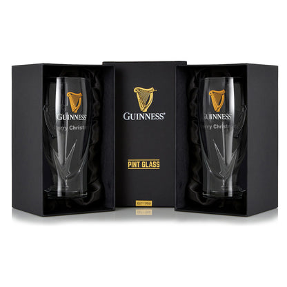 The Guinness Pint Glass - 2 Pack by Guinness UK includes two pint glasses in black gift boxes, featuring logos and "Merry Christmas" text, perfect for enhancing any beer glass collection and enjoying a festive pint.