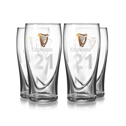 A set of four Guinness Pint Glasses from Guinness UK, featuring the iconic logo and number 21, is elegantly arranged in two rows.