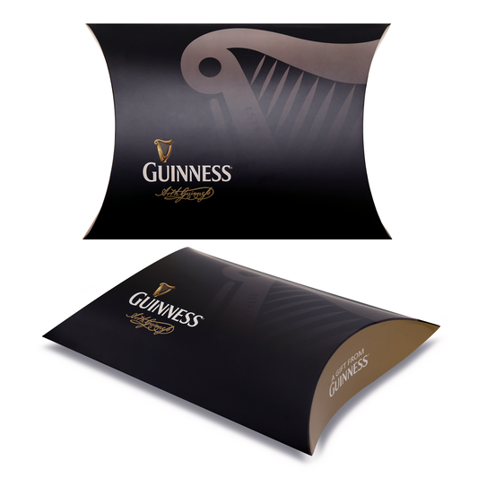 Two views of the Guinness Pillowcase Gift Box—a black box with the Guinness logo, gold harp graphic, and "A Gift from Guinness" in gold script—ideal for fans and collectors seeking unique gifts.