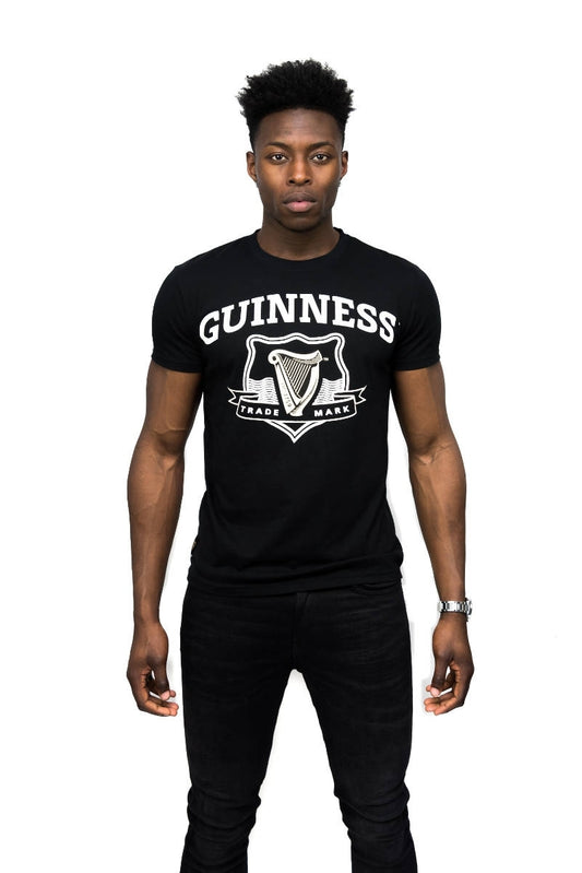 A man wearing a black Guinness UK Guinness Black Trademark Label T-Shirt.