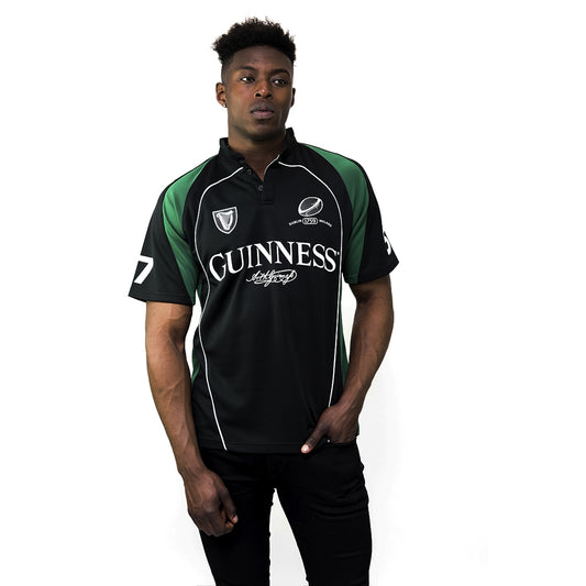 A man wearing a black and green Guinness UK short sleeve performance rugby jersey.