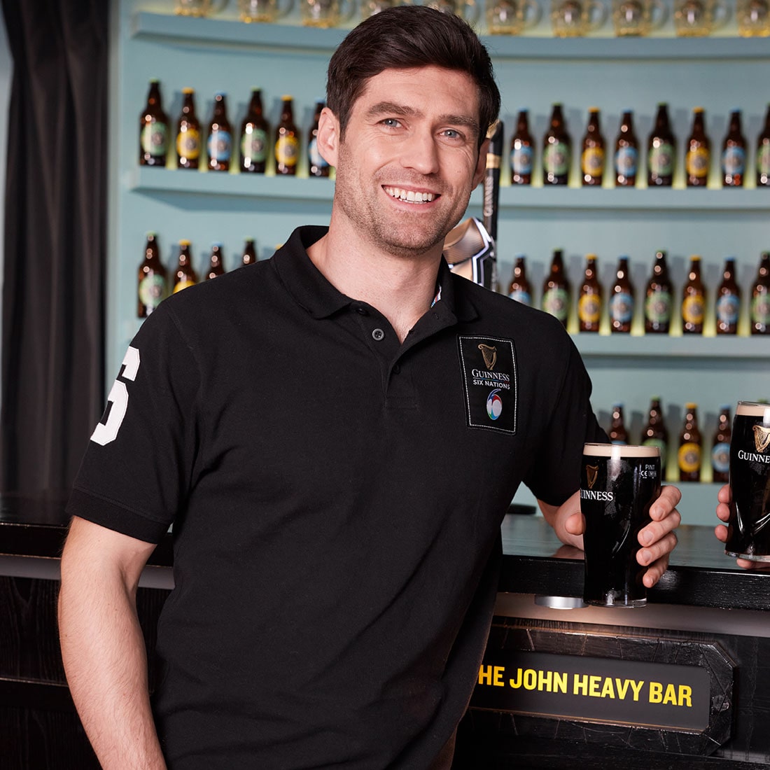 A man wearing a Guinness UK Six Nations Black Polo shirt.