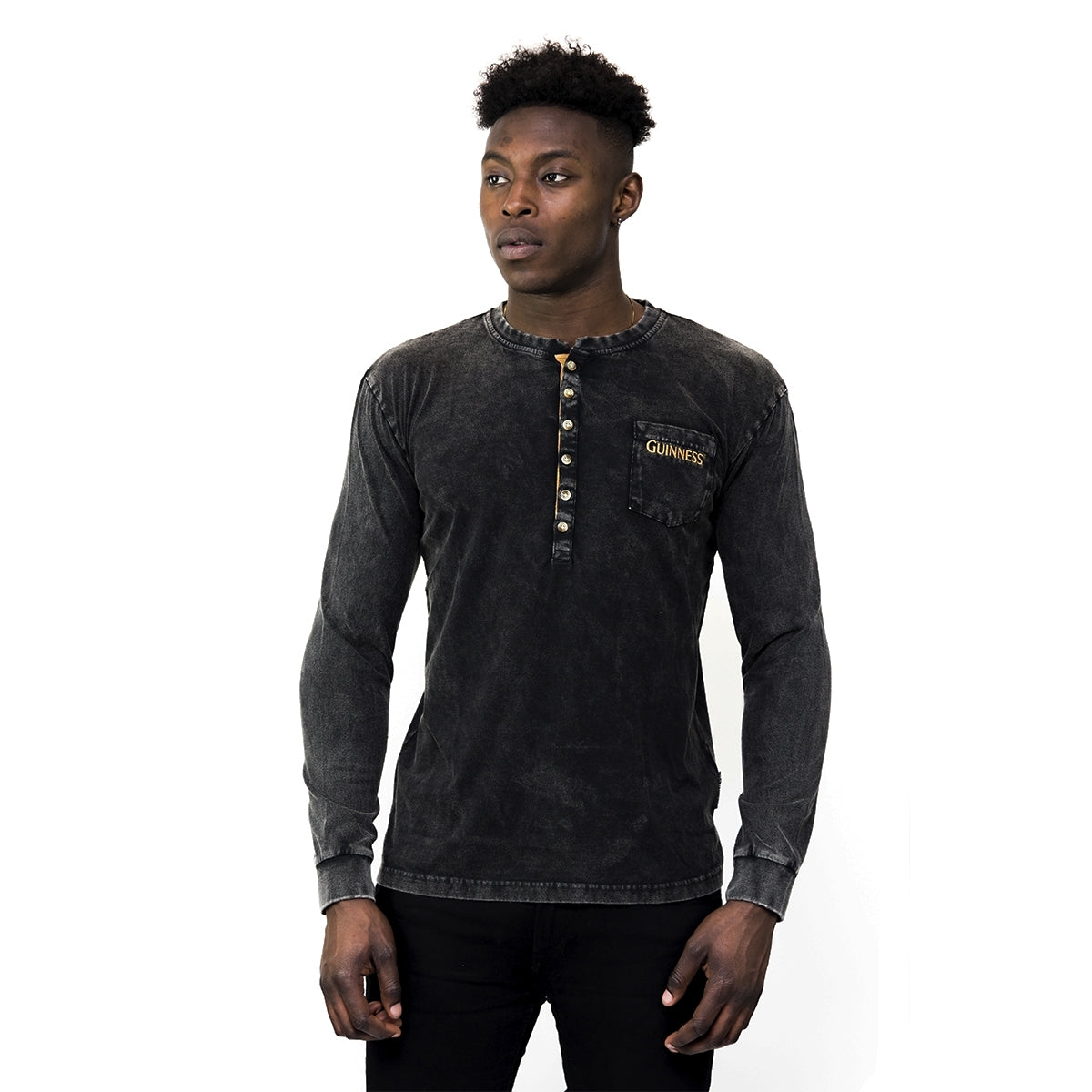 A man wearing a durable black Guinness UK Classic Henley t-shirt.