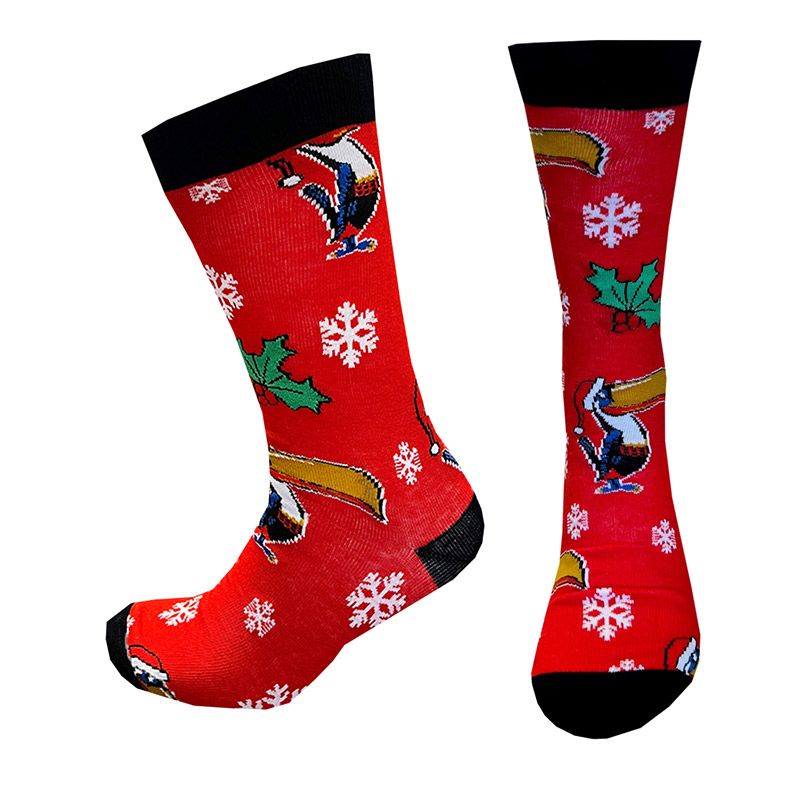 The Guinness Toucan Snowflake Socks from Guinness Webstore UK feature distinctive red designs of penguins, sleds, snowflakes, and green holly leaves with black trim on the toe and cuff.