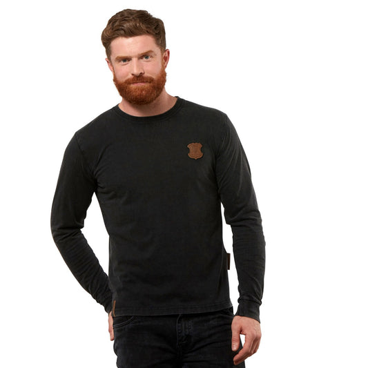 A bearded man stands against a white background, wearing a black Long Sleeve Premium Tee from Guinness UK.