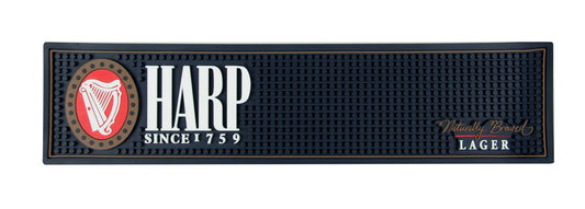 The Harp Lager PVC Bar Mat by Guinness UK features the iconic "Harp" logo, with the text "Since 1759" on the left and "Naturally Brewed Lager" on the right, making it a perfect addition to your home bar setup.