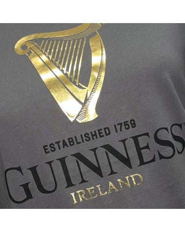 Close-up of a Guinness Gold Foil Harp T-Shirt featuring the golden harp logo and the text "Guinness Ireland established 1759" from the Guinness Webstore UK.