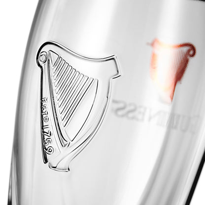 Close-up of a Guinness Embossed Pint Glass - 500ml Can Size with the Harp logo artfully reflecting onto the surface.