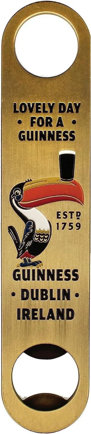 The Guinness Gilroy Barman Bottle Opener from the Guinness Webstore UK features a gold finish with the iconic "Lovely Day for a Guinness" text and a playful toucan illustration. This exclusive piece of barware proudly displays the "ESTD 1759 Guinness Dublin Ireland" inscription.