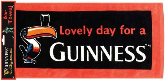 The Guinness Gilroy Bar Towel from Guinness Webstore UK features a vibrant red and black design, depicting the iconic toucan balancing a glass of beer on its beak with the well-known phrase, "Lovely day for a Guinness." It's an ideal accessory for any fan of the brand.